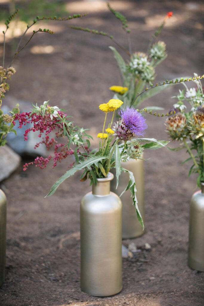 Gold painted bottle with wildflowers.