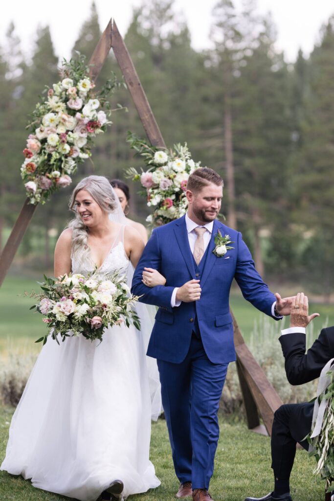 Wedding couple walking back up the aisle arm in arm.