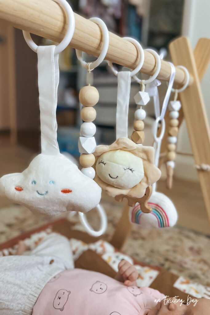 Baby play gym made of wood with hanging plush toys.