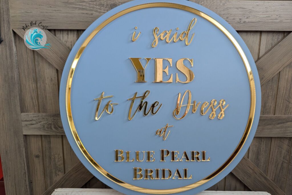 Light blue acrylic sign with gold acrylic overlay reading "I said YES to the dress at Blue Pearl Bridal".