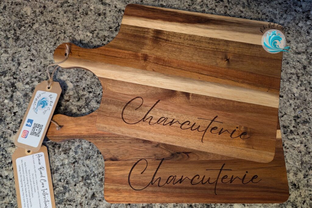 Acacia wood cutting boards with "Charcuterie" engraved near the edge of each board.